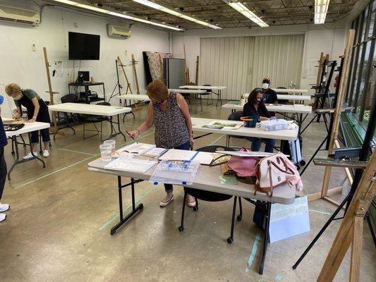 Watercolor painting class during COVID-19. Students wear masks and maintain distance in individual work stations