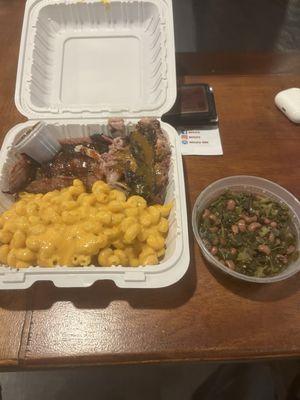 Two meat plate with brisket, pulled pork, Mac and cheese and greens with black eyed peas.