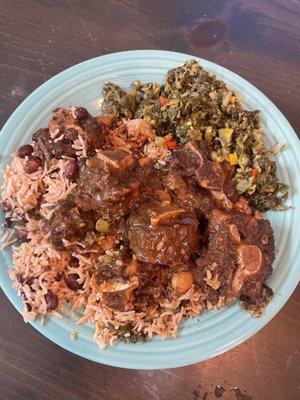 Oxtail, rice and peas, callaloo. The plate and table is mine, it was takeout.