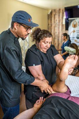 Community Wellness free 30-minute student massage. Dr. Dan giving pointers to his students