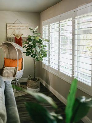 Beautiful and classic, white plantation shutters easily cover a wall of windows and provide the lighting and privacy options needed.