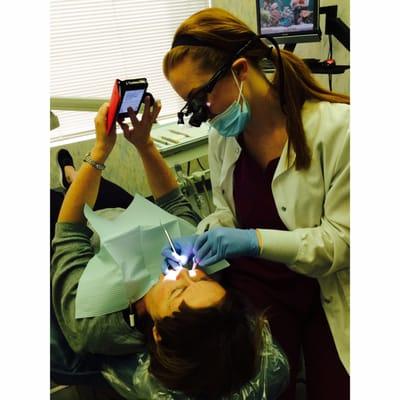 Here is a picture of the hygienist cleaning Dr. Brown's wife's teeth (while she texts)!