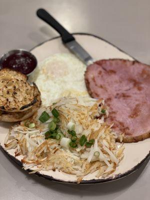 Simple breakfast of over easy eggs, ham and shredded potatoes.