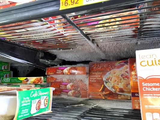 Boxes frozen solid to the shelf in a freezer case. Are they turning down the freezer at night and allowing it to thaw and refreeze?