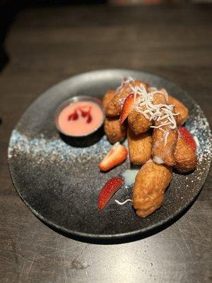 Korean fried donuts with strawberry glaze and vanilla shavings. Raspberry & Strawberry dipping sauce.