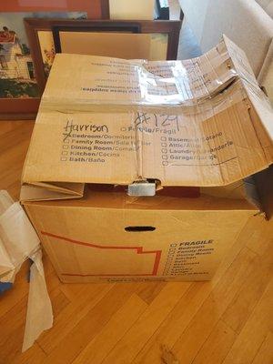 a thick cardboard wardrobe box with a metal reinforcement was smashed to half its size