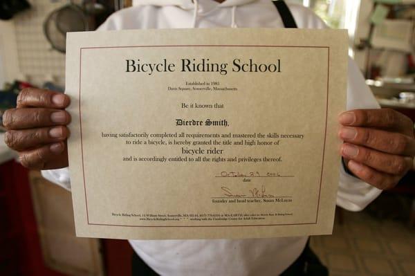 A student proudly displays her diploma