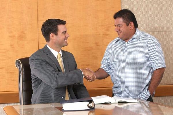 Attorney/owner Nick Alcock greeting a happy client