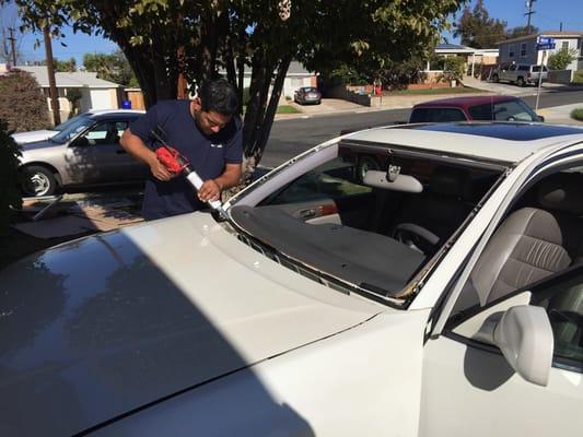 Caulking the frame before installing the new windshield.