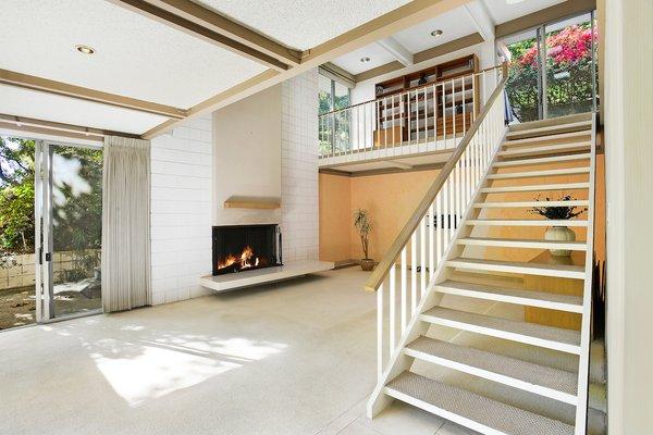 Dramatic two story open floor plan living room with wood-burning fireplace