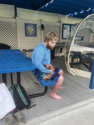 My son waiting for his  lesson near clear pods with adjustable heaters next to the pool