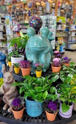 Blooming plants and garden accents in the greenhouse