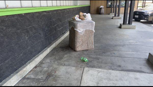 Trash piled up at entrance, and  filthy sidewalk.