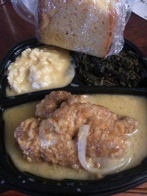 Smothered chicken, mashed potatoes, greens and cornbread.