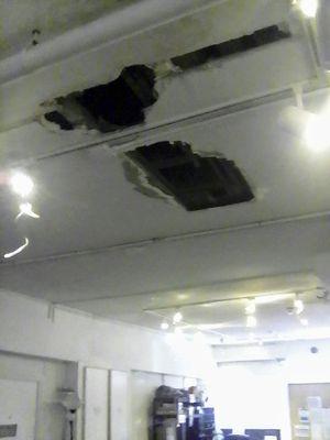 The broken ceiling in a living /dining / office room. It's been like this for a few months. The building is obviously crumbling down.