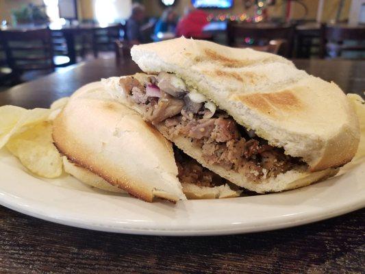 The fresh baked cheesesteak sub with potato chips.