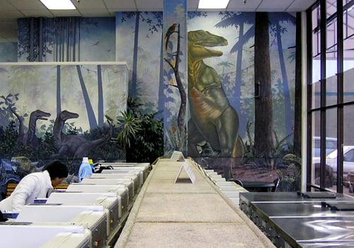 Painting of a big T-Rex overlooks the interior of the laundromat.