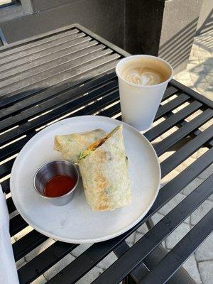 Latte and breakfast burrito on the nice outdoor table