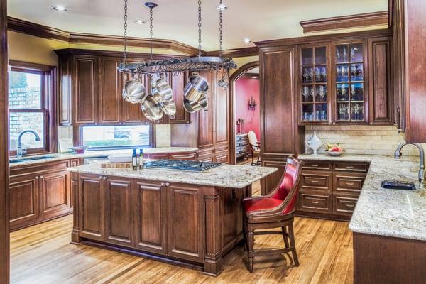 This Houston kitchen sports stained cherry exteriors with a gorgeous hanging rack for pots and pans over the island.