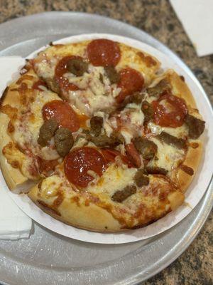 Personal pizza with pepperoni and sausage.