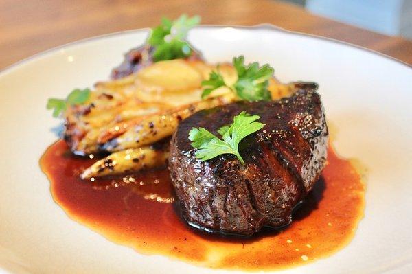 The Bison Tenderloin Medallion is made with tartiflette potato, huckleberry bacon jam, roasted heirloom carrots and au jus.