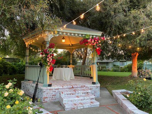 Gazebo! No need for wedding arch... you can attach flowers directly to the gazebo.