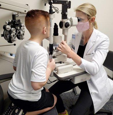 Doctor performing an eye exam on a young boy at True Eye Experts Lutz.