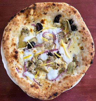 "Olive-it" pizza made with kalamata olives, artichokes, red onion, burrata, mozzarella, grana padano cheeses, chilli flakes, and lemon zest