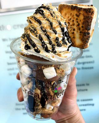 S'mores Creation featuring layers of rich chocolate ice cream, graham crackers, mini marshmallows, fudge, and a toasted marshmallow.