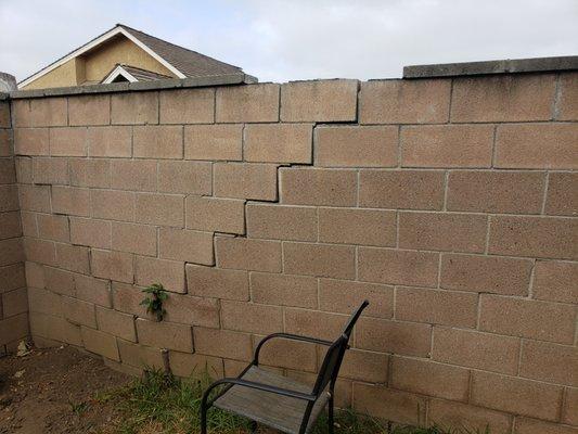 Before demolition of the block wall. A palm tree grew in the easement causing the wall to look like this.