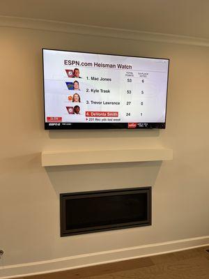 65" TV mounted above fireplace