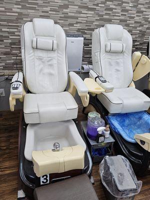 Pedicure chairs have massaging backs. The blue disposable plastic bag is placed in the foot soak bowl for cleanliness for each customer