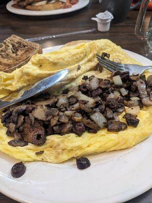 Inside omelet is onion, mushroom, black olive