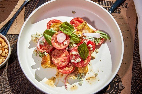 Tomato Salad - tomatoes and blue cheese tossed in herb dressing, with red onion, croutons, and basil