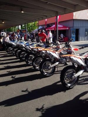 Before the crowd, a line of street legal ktm enduros.