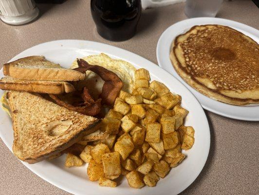 Eggs, home fries, bacon, toast and a pancake.