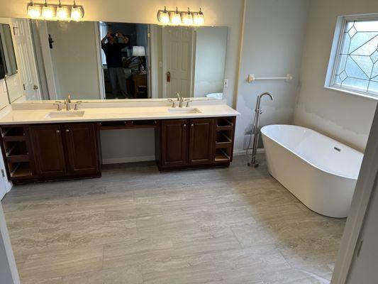 New large format tile flooring with a crisp new quartz countertop ,soaking tub & fixtures