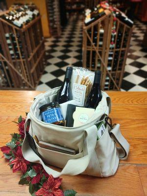 A gift bag idea, wine, breadsticks, and olives in a ivory wine cooler bag.