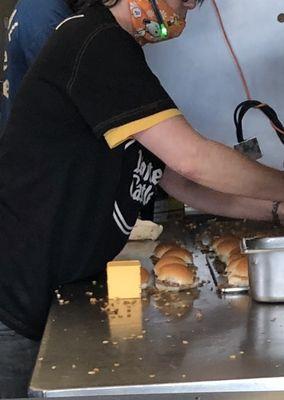 Dirty rag on the far end on the food prep table, Employee clothes on the food prep table. Mask worn under the nose.