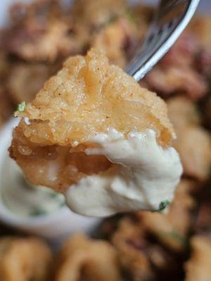 Close-up of a piece of the Fried Calamari appetizer on a fork.