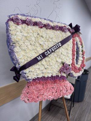 Flower display of a cup with cafecito ribbon