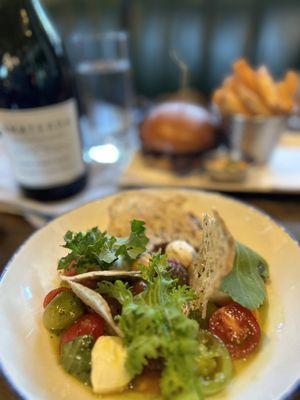 Heirloom tomato and mozzarella salad with a tasty burger & fries in the background!