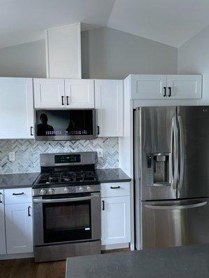 Installed the cabinet and microwave over the stove (plus custom vent cover), and cabinet and side panel over fridge