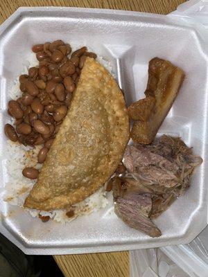 White Rice w Beans, empanada, pernil (pork) and a piece of chicharron.