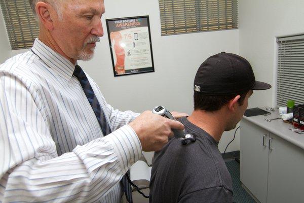 Dr. Smith using the Impulse IQ Adjusting Tool, another way to adjust the spine without using a manual adjustment.