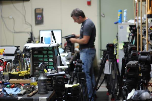 Repair area with George H. working on a tripod head.