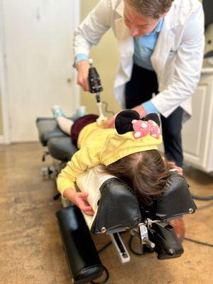 Dr. Moore using one of the tools they have to adjust my daughter. He was very kind and gentle with her.