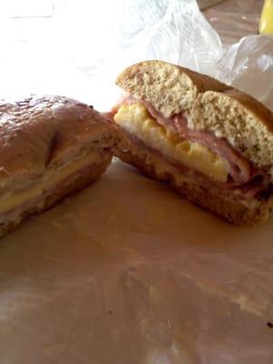 Egg, ham and cheese sandwich on a fresh whole wheat bagel.