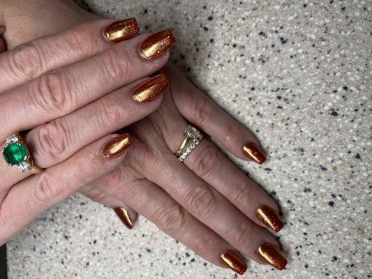 The combo of a read sparkle underlay and the gold toned chrome makes these nail look like fire!