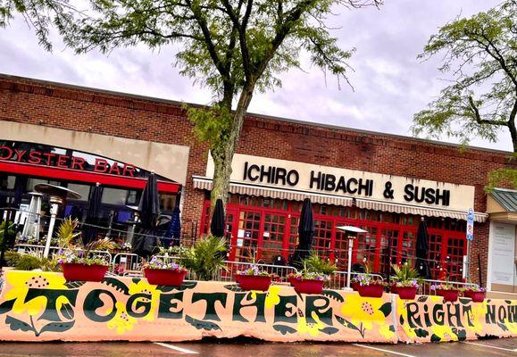 Outdoor seating - May 2021 - the barricade art reads "Come Together Right Now"